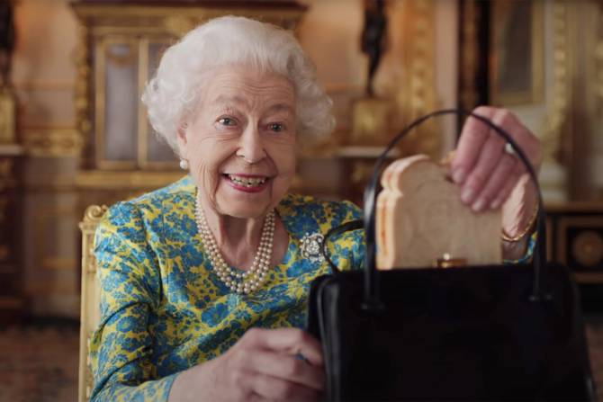 Queen Elizabeth pulls a marmalade sandwich out of her handbag in a sketch with Paddington