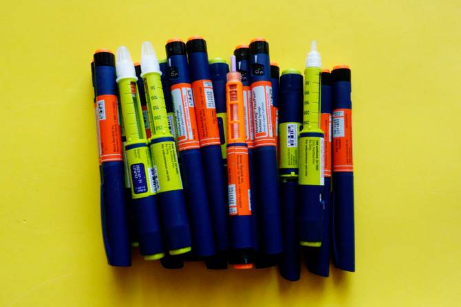Still life of Tresiba insulin pens on yellow.