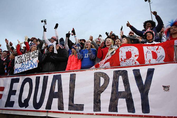 USA fans with an 'Equal Play Equal Pay' banner supporting the women play...