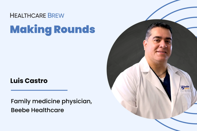 A man in a white coat smiles.