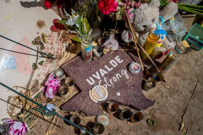 A sign surrounded in gifts is seen at a memorial in front of Robb Elementary School on June 17, 2022 in Uvalde, Texas