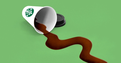 A Starbucks cup of coffee spilling out on its side onto a greed background