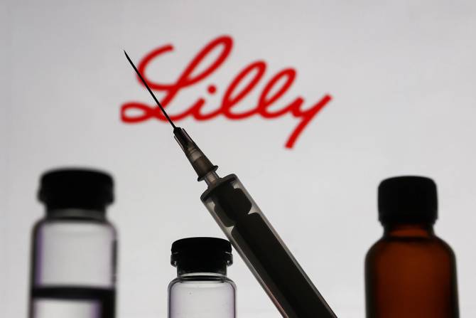Syringe outline in front of medicine vials and Eli Lilly logo.