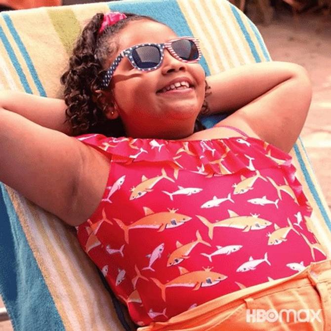 A pre-adolescent girl from the Max show Gordita Chronicles relaxes by the pool in a swimsuit 