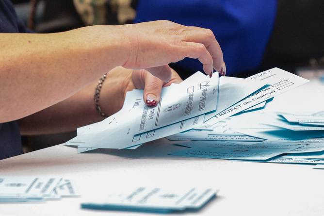 a woman handling blue union ballots