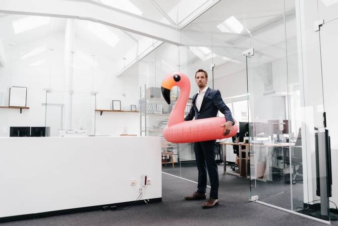 person in suit with pink flamingo floatie