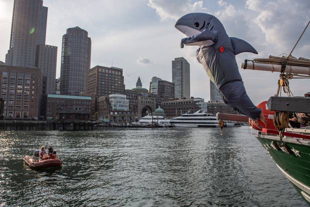 Costumed revelers walk the plank and jump off the tall ship Denis Sullivan and into Boston Harbor during a heatwave in Boston, Massachusetts,