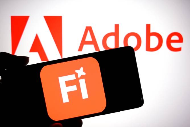 Adobe's Firefly app is seen in front of an Adobe logo on a screen