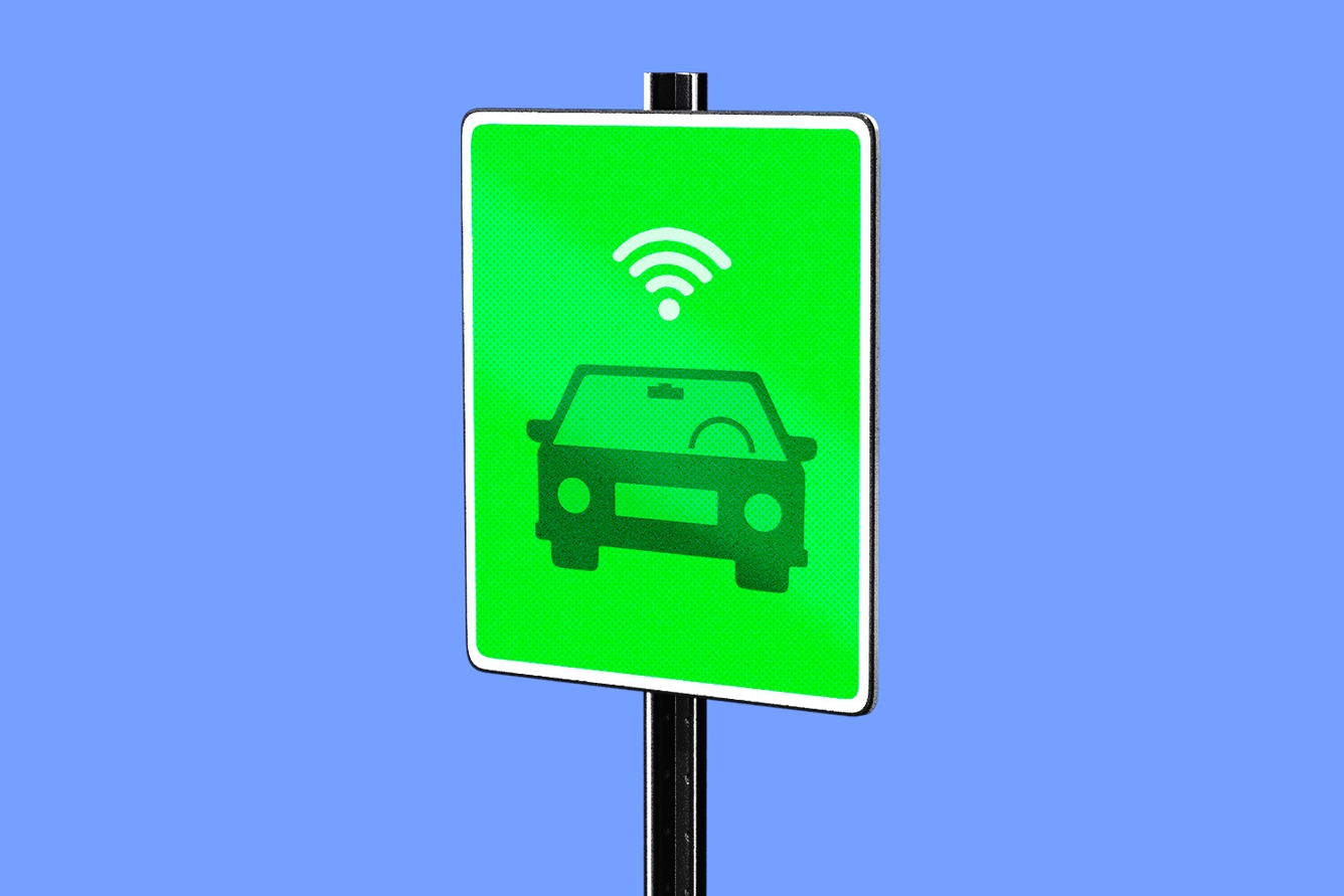 Road sign of a car icon and wifi symbol above.