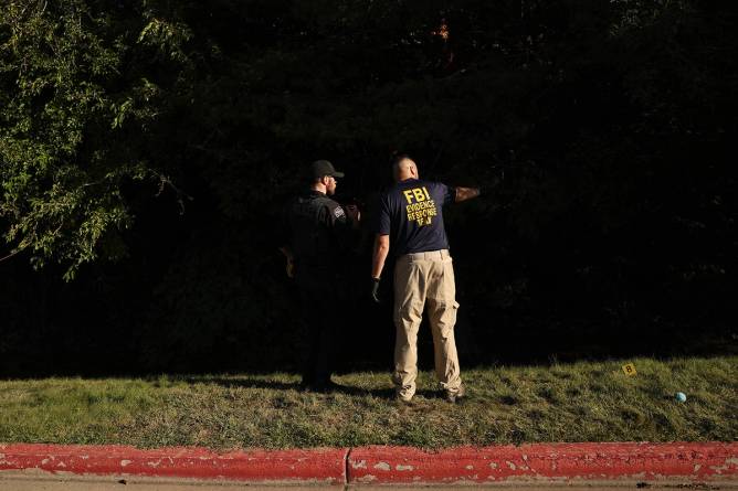 FBI officials investigate a wooded area near the scene of the shooting of Charlie Kirk