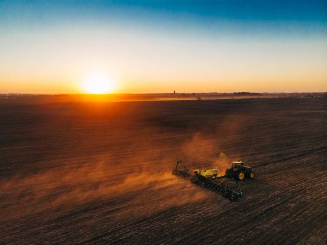 image of tractor in sunset planting Pivot Bio product