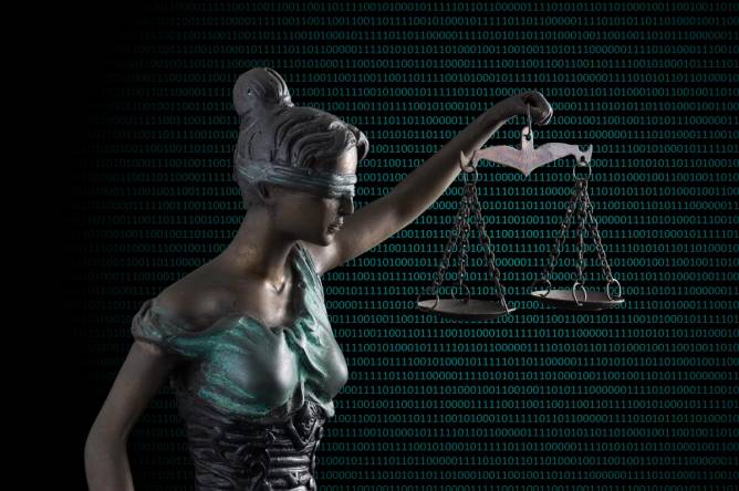 A statue of Lady Justice with scales in front of an array of code.