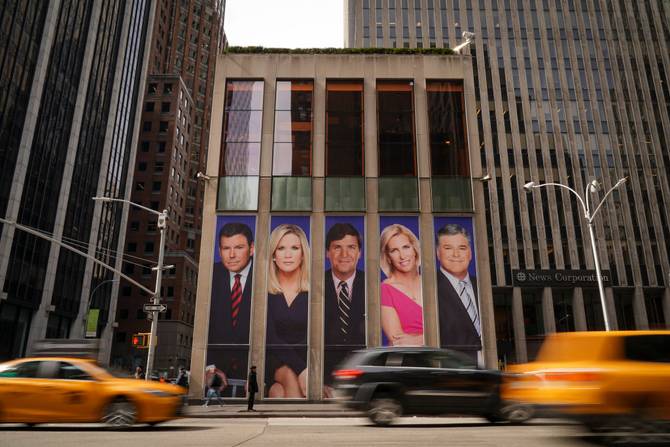 Traffic on Sixth Avenue passes by advertisements featuring Fox News personalities, including Bret Baier, Martha MacCallum, Tucker Carlson, Laura Ingraham, and Sean Hannity