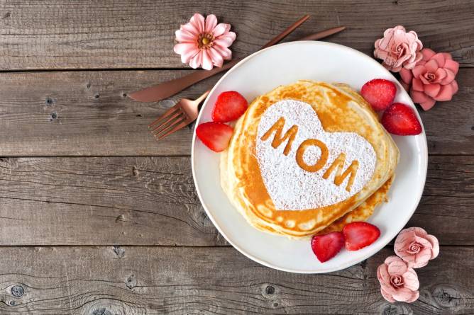 Image of pancakes with "MOM" dusted on them in powdered sugar.
