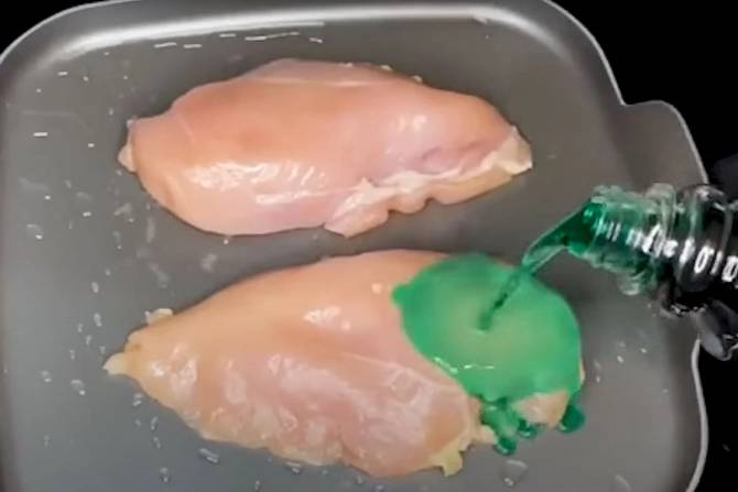 A still from a TikTok video shows cough syrup being poured over a chicken breast as it cooks in a frying pan. 