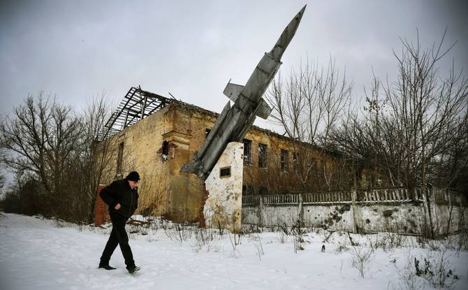 A man walks past a destroyed building of a former military installation in Eastern Ukraine