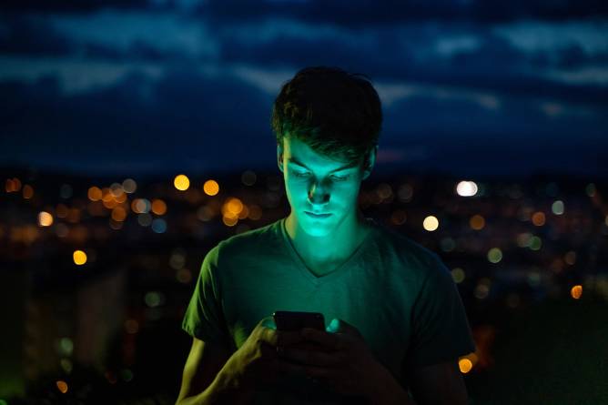 Teen illuminated by smartphone glow