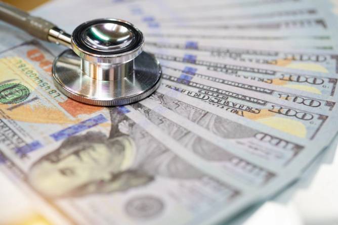 A stethoscope on a pile of money.