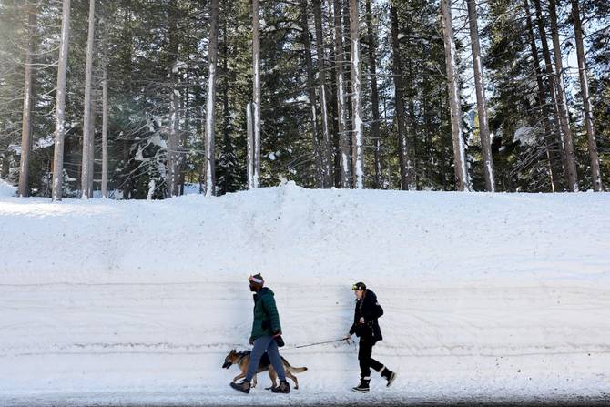 People walk past a giant snowbank in California