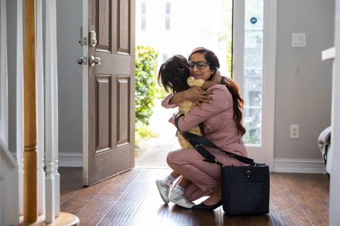 A child greeting her mother who has arrived home form work