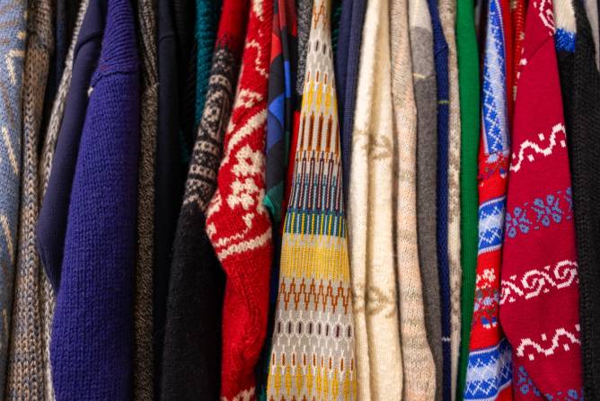  Clothing rack of vintage sweaters at antique flea market