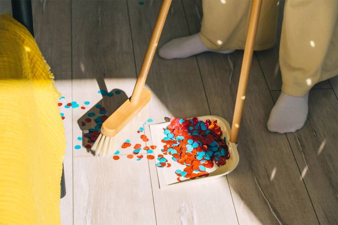 a woman sweeping confetti off the floor