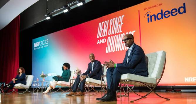 Panelists on stage at an NRF Big Show panel in 2022, “The Achievable How: Implementing DE&I learnings inside your business.”