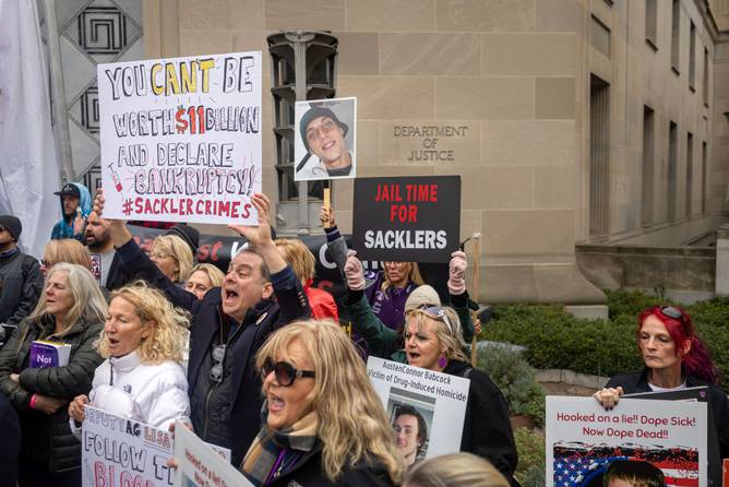 People protesting the Sackler opioid settlement outside the DOJ