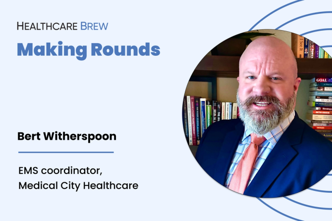 A bald man with a beard smiles at the camera.