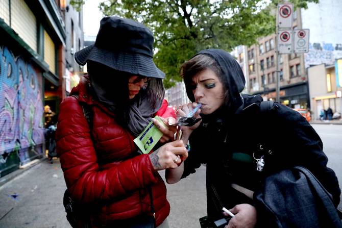 Shyan Willow, 27, left, and Kia Haim, 39, smoke fentanyl along East Hastings Street in the Downtown Eastside (DTES) neighborhood on Tuesday, May 3, 2022 in Vancouver, British Columbia