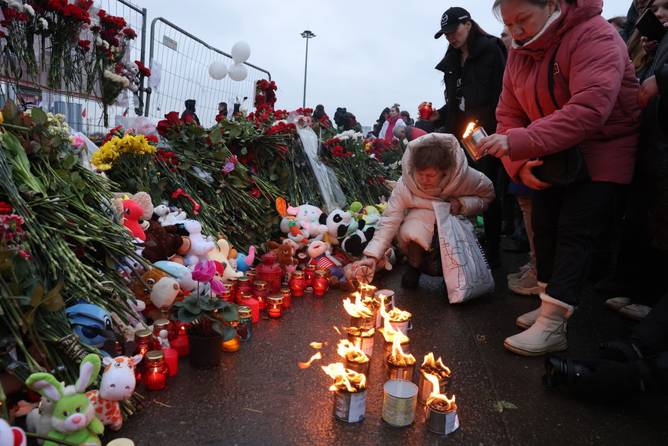 People light candles in honor to the victims of the Crocus City Hall terrorist attack near the Crocus City Expo Complex on March 23, 2024 