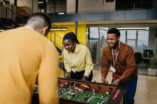 Colleagues play foosball.