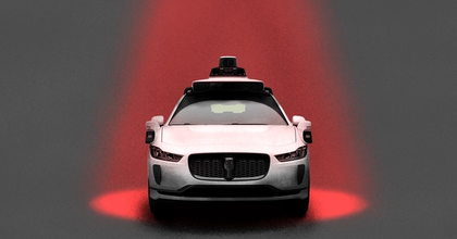 A driverless car with a red spotlight shining on it from above
