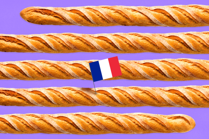 A baguette so large in goes in and out of the frame with a French flag