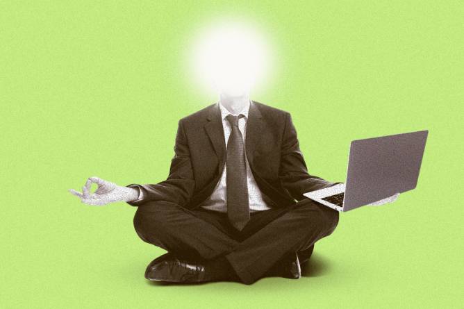 Person in a suit meditating while holding a laptop