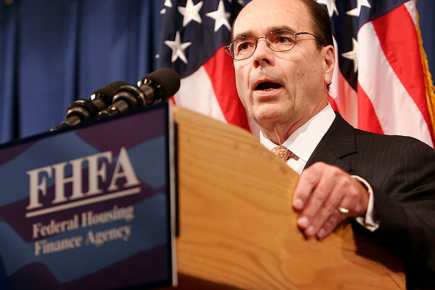 Man in suit speaks at podium, Federal Housing Finance Agency.