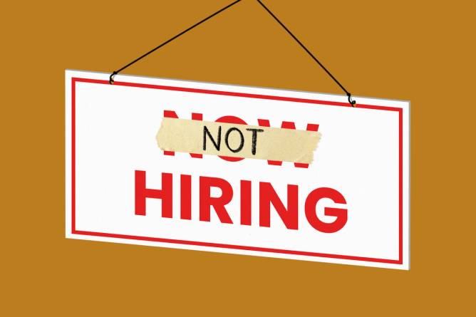 A Now Hiring sign with Now crossed out and replaced with Not