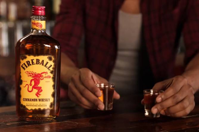 a bartender serves two shots of Fireball 