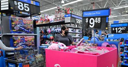 A shopper wearing a medical mask looking through a Barbie bin inside of a Walmart