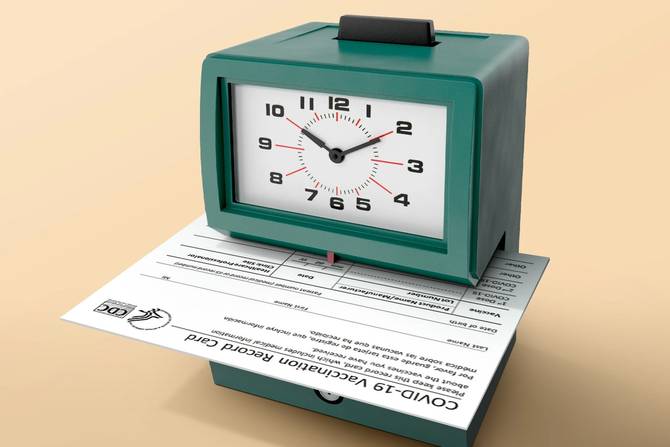 A vaccination card in an employee timesheet punchcard machine.