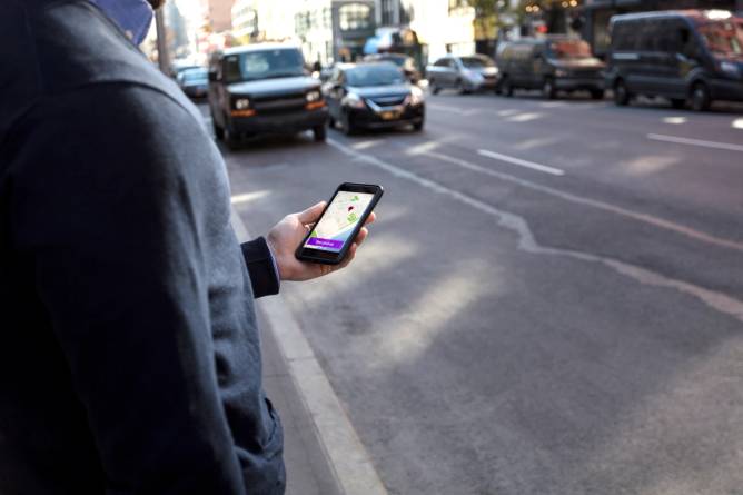 Man holding phone waiting for car