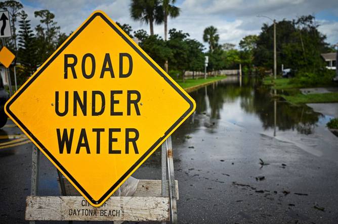 A road under water sign after Hurricane Milton