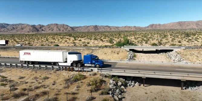 A semi truck outfitted with the Revoy EV drives on a freeway.