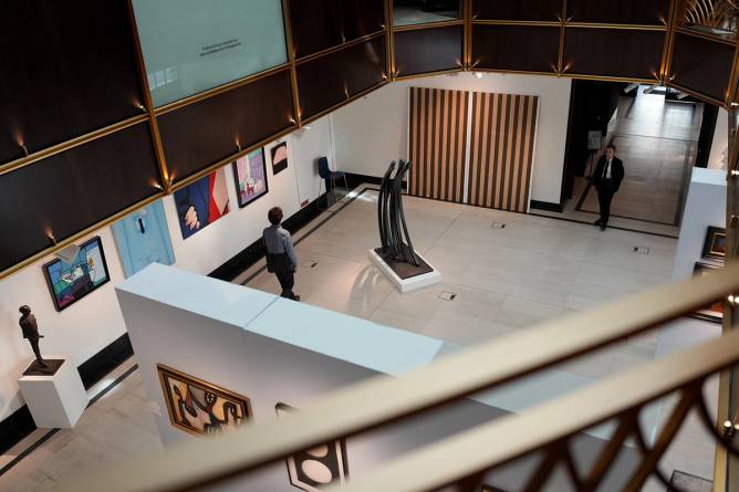 A view of Sotheby’s Paris auction house showing visitors observing contemporary artworks and sculptures.