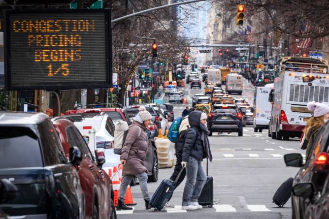 pedestrians cross a busy new york city intersection 