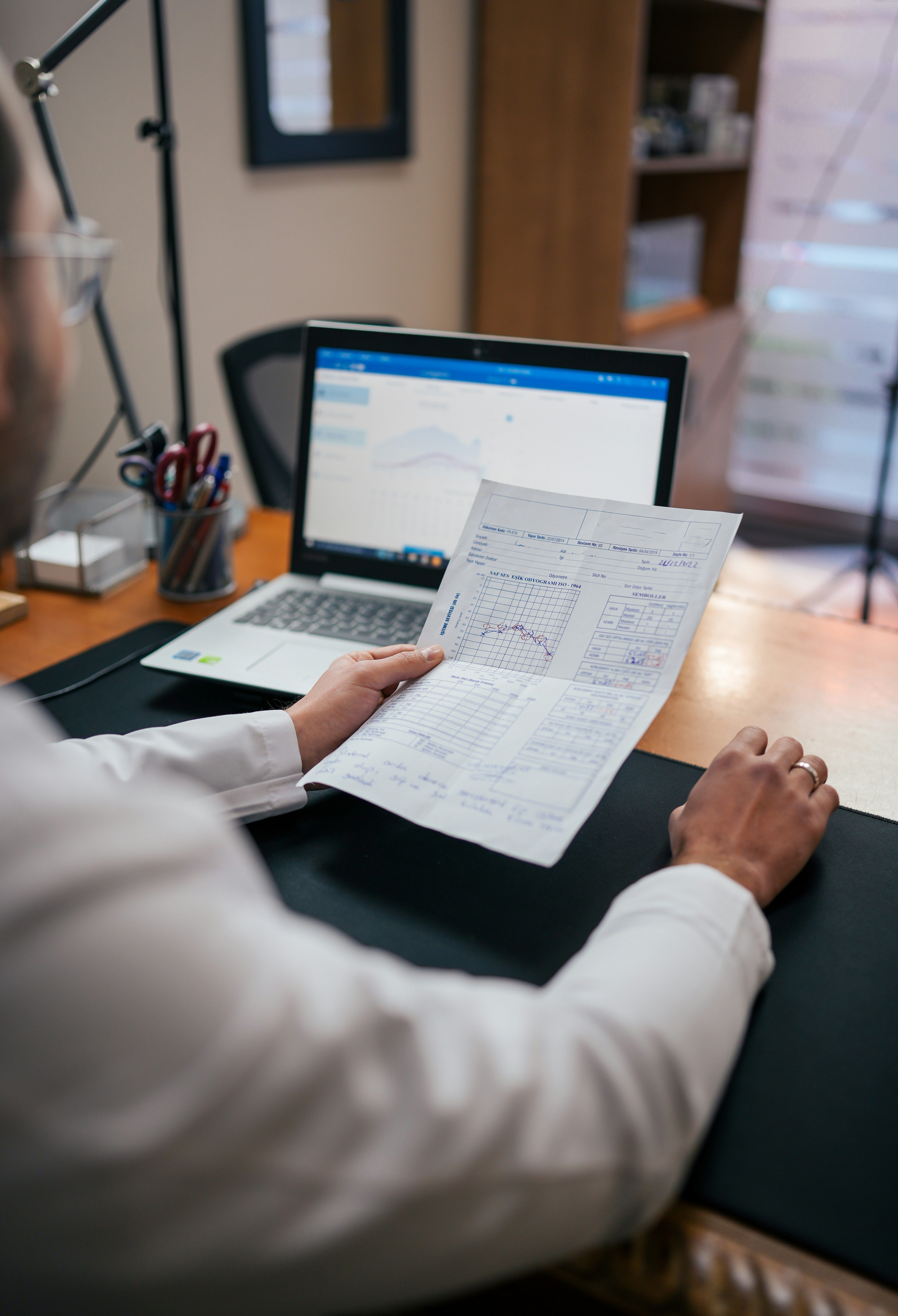 Doctor looking at medical record and computer.