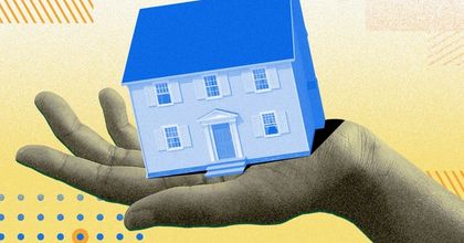 A hand holding a miniaturized two-story home