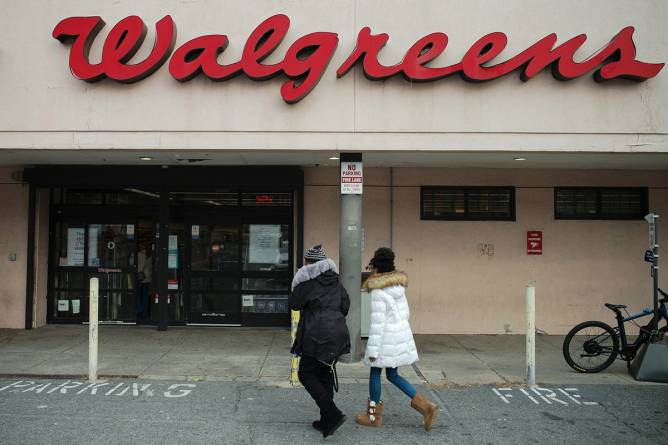 Two customers walking into a Walgreens.