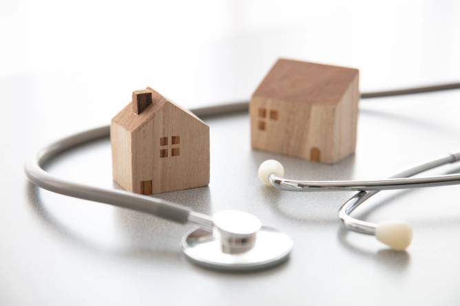 A stethoscope next to two toy houses. 