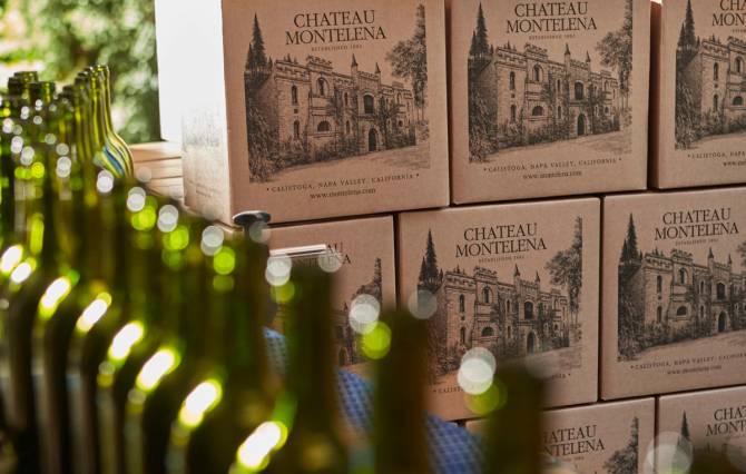 Bottles of wine lined up alongside Chateau Montelena wine boxes